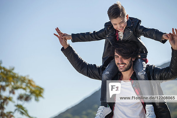 Father and son outdoors  father carrying son on shoulders