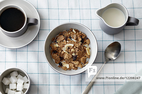 Cereal with dried fruit  coffee and milk jug  overhead view