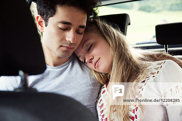 Ehepaar auf dem Rücksitz eines Autos schläft