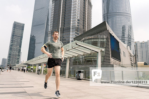 Young male runner running in Shanghai financial centre  Shanghai  China