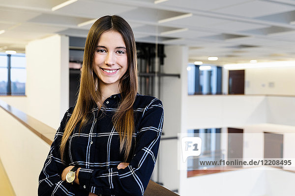 Portrait of young businesswoman in office atrium