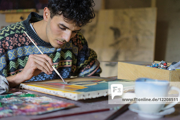 Männlicher Künstler malt Leinwand im Künstleratelier  beschnitten