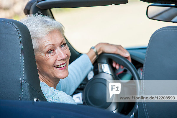 Porträt einer älteren Frau in einem Cabriolet