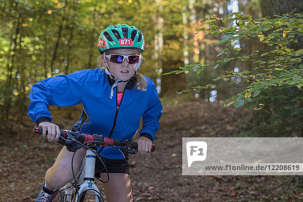 Mountainbike-Mädchen bereitet sich auf das Radfahren im Wald vor