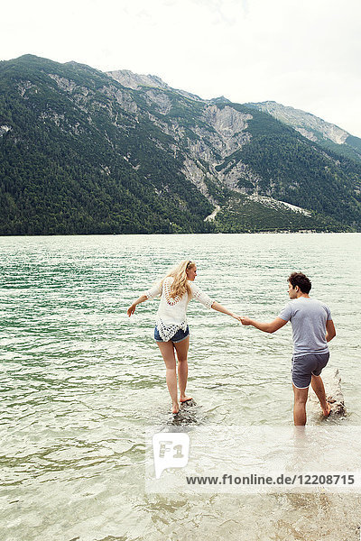 Couple in shallow water holding hands  Achensee  Innsbruck  Tirol  Austria  Europe