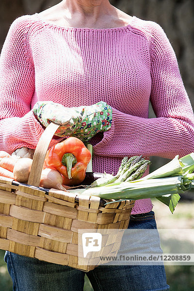 Frau mit Korb mit selbst angebautem Gemüse