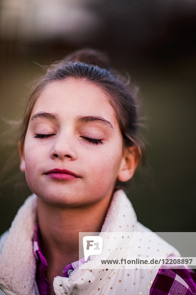 Portrait of girl  outdoors  eyes closed  thoughtful expression