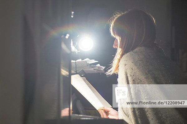 Frau liest am Schreibtisch mit Tischlampe