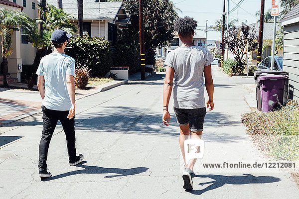 Friends walking down sunny street  Long Beach  California  US