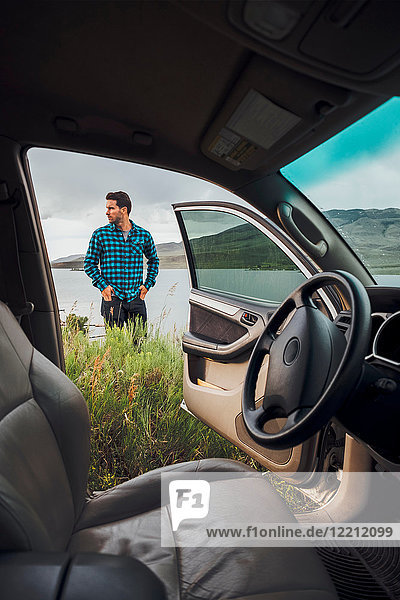 Mittelgroßer erwachsener Mann am Dillon-Stausee stehend  Blick durch geparktes Auto  Silverthorne  Colorado  USA