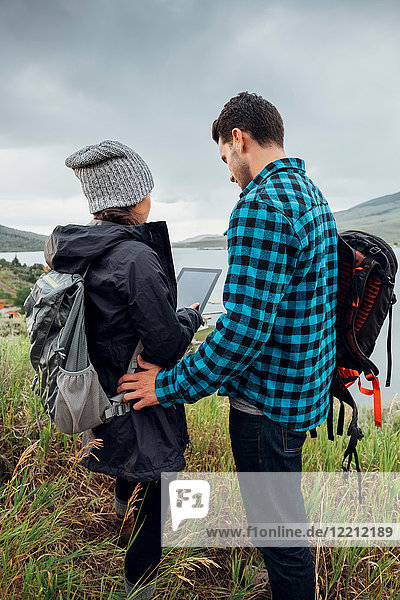Couple standing beside Dillon Reservoir  using digital tablet  Silverthorne  Colorado  USA
