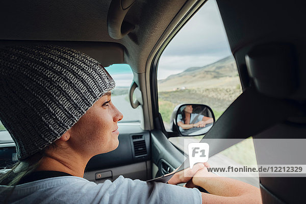Young woman sitting in car  looking at view out of car window  Silverthorne  Colorado  USA
