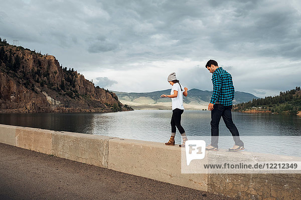 Couple walking along wall beside Dillon Reservoir  Silverthorne  Colorado  USA