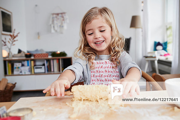 Young girl rolling out cookie dough  dough stuck to rolling pin