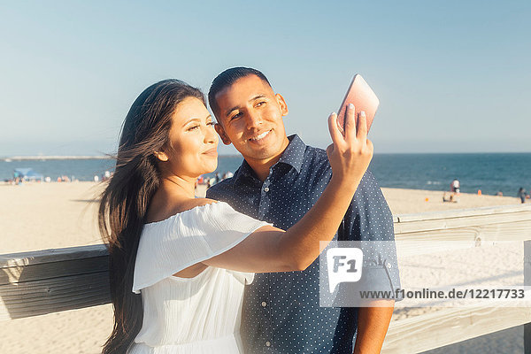 Paar am Strand  Selbstgespräch  mit Smartphone  Seal Beach  Kalifornien  USA