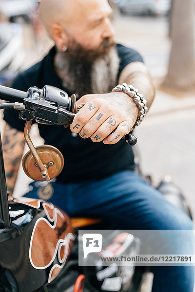 Gereiftes männliches Hipster-Ride-Motorrad  Nahaufnahme der tätowierten Hand