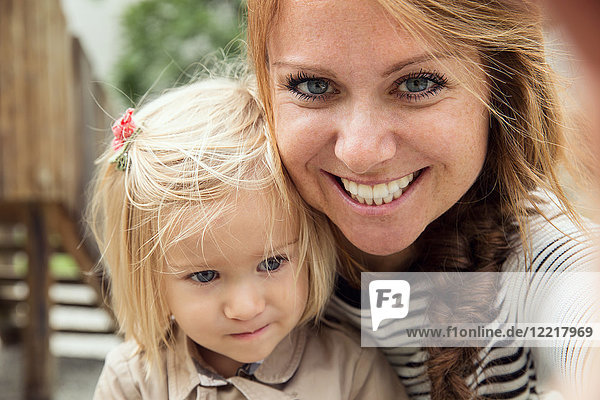 Portrait of mother and toddler daughter in park  close up