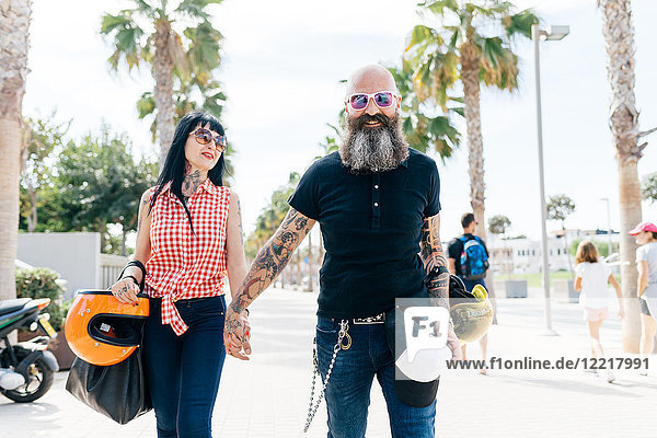 Portrait of mature hipster couple strolling on sidewalk  Valencia  Spain
