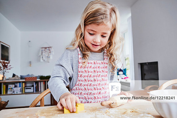 Junges Mädchen macht Kekse  mit der Keksausstechform