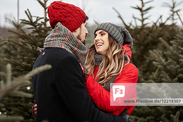 Romantisches junges Paar kauft Weihnachtsbaum aus dem Wald