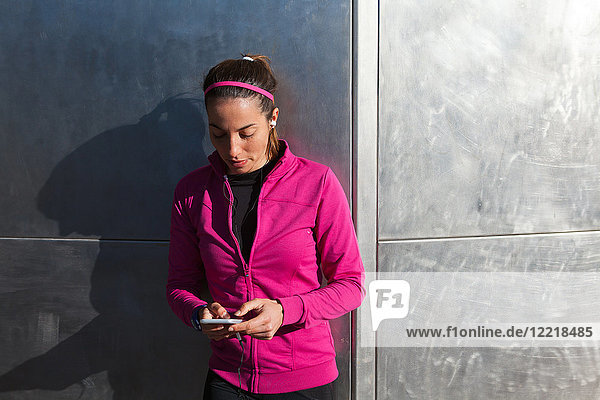 Junge Frau schreibt SMS auf Smartphone