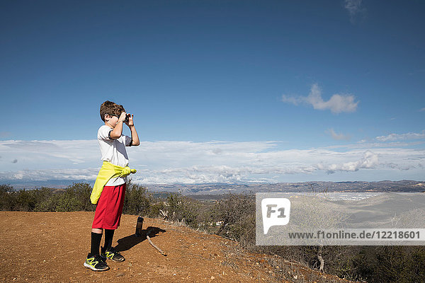 Boy exploring with camera in hills  Thousand Oaks  California  US