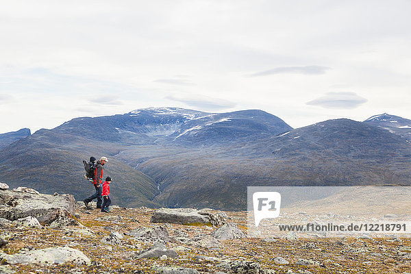 Mann mit Söhnen beim Wandern in der Berglandschaft  Jotunheimen-Nationalpark  Lom  Oppland  Norwegen