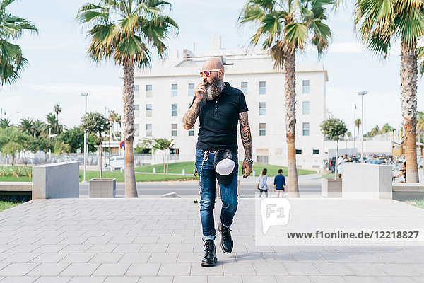 Älterer männlicher Hipster raucht Zigarette und geht in der Stadt spazieren  Valencia  Spanien
