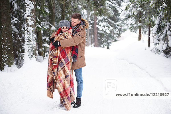 Young couple hugging in snow