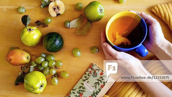 High Angle View of Cup of Swirling Tee und Obst