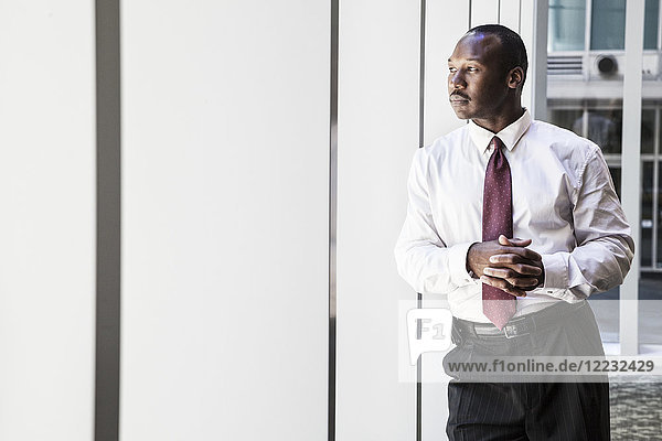 Black businessman in lobby of large business centre.