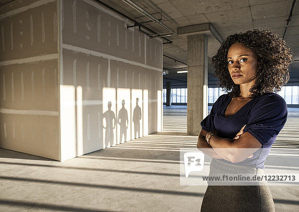 Schwarze Geschäftsfrau  die in einem leeren  rohen Büroraum steht.