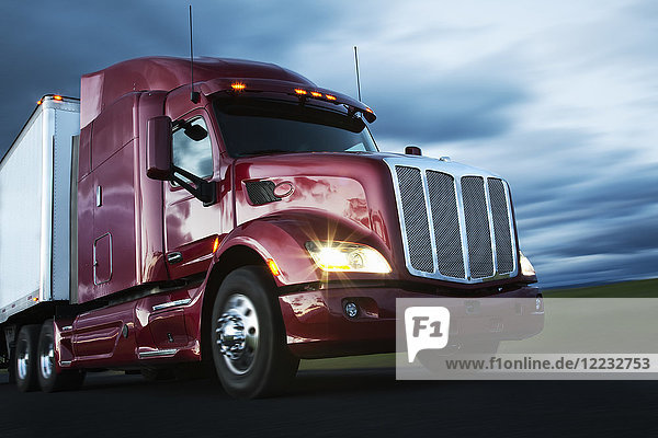 Front to rear low angle view of the cab of a commercial truck on the highway late in the day.