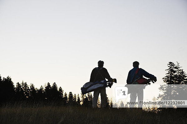 Zwei Senioren gehen das Fairway hinunter zum nächsten Golfplatz.