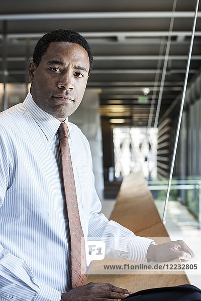 Black businessman in the lobby of a large office building.