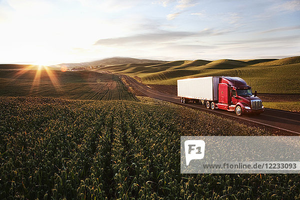 Ein kommerzieller Lastwagen der Peterbilt Class8 fährt bei Sonnenuntergang durch Ackerland im Osten Washingtons  USA.