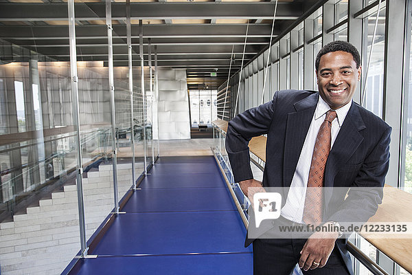 Black businessman in the lobby of a large office building.