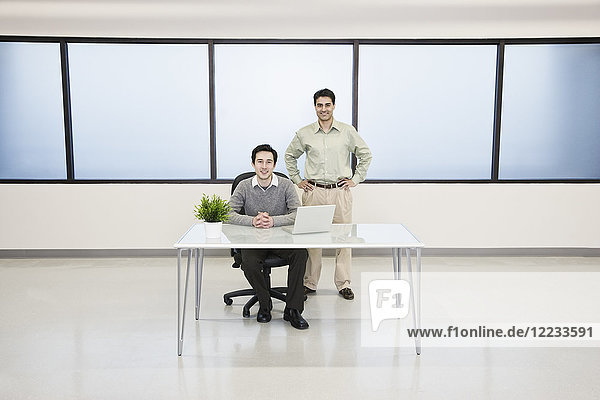Team of two Caucasian businessmen in a computer server farm office.