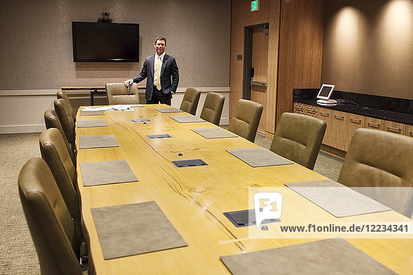 Businessman at the head of a large conference room table.