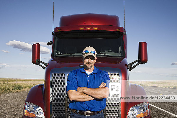 Portrait of a Caucasian man driver and his commercial truck.