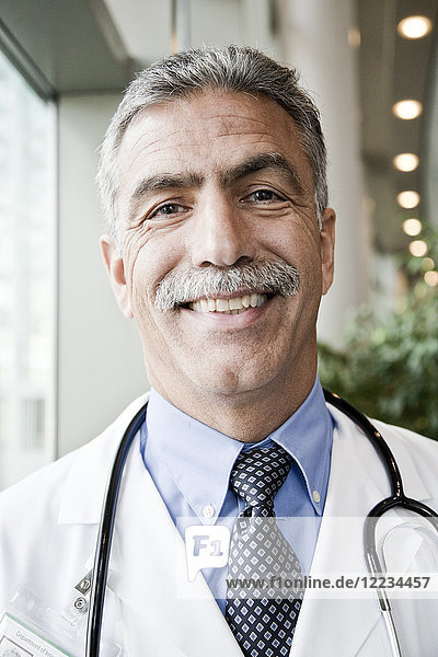 Middle Eastern man doctor in lab coat with stethoscope.
