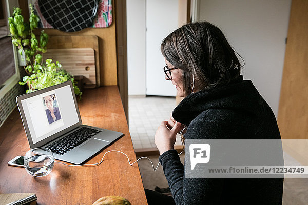 Seitenansicht der Geschäftsfrau Videogesprächskollegin am Laptop im Home-Office