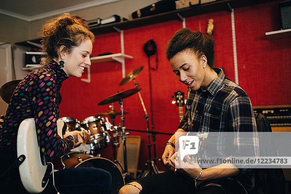 Freunde beim Gitarre spielen während des Übens im Tonstudio