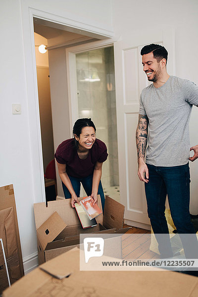 Couple enjoying while unpacking boxes in new apartment