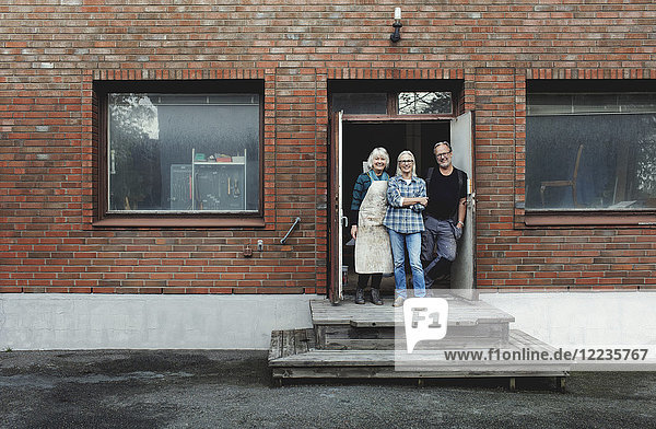 Volle Länge der Senioren  die am Werkstatteingang stehen