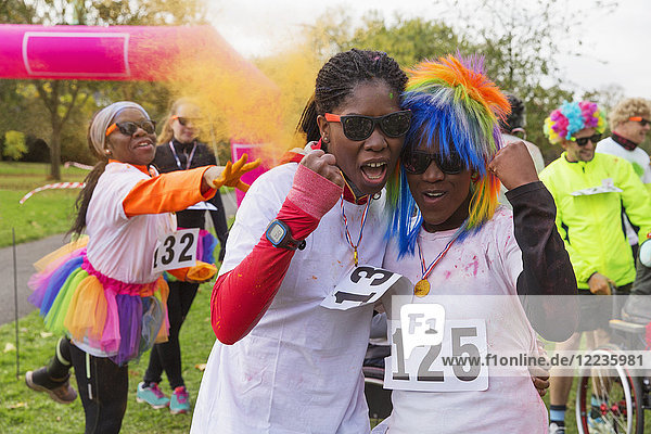 Portrait confident  enthusiastic female runners cheering at charity run in park