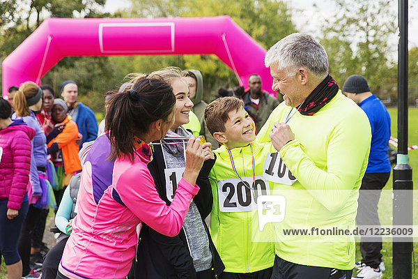 Happy family with medals finishing charity run  celebrating