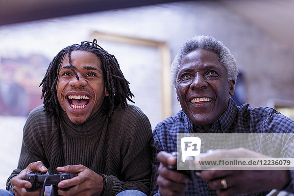 Begeisterter Großvater und Enkel beim Videospielen