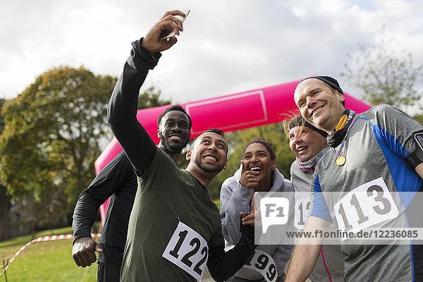 Friend runners taking selfie at charity run in park