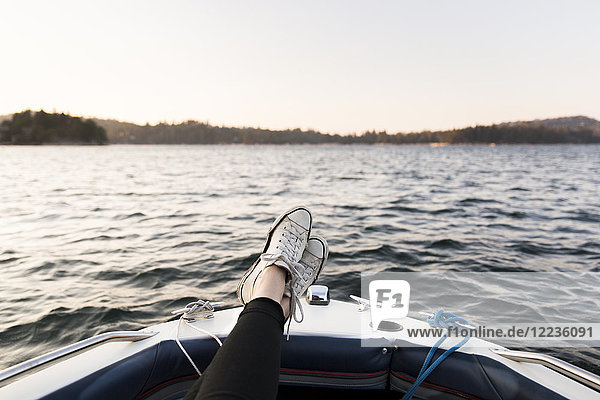 Persönliche Perspektive Frau Bootfahrt mit Füßen oben auf dem ruhigen See